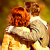 Clint Barton with his arm around Natasha Romanoff, their backs to the viewer, bright colours